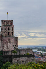 closeup of the heidelberg castle tower and a wide panoramic view of the landscape with the city, river and mountains in the back