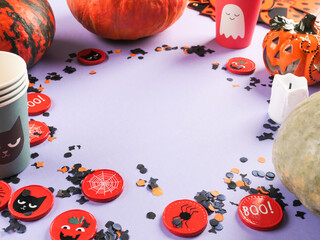 Halloween purple frame background flatlay with pumpkins and party decor