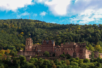 The beautiful Heidelberg Castle on a slightly cloudy sunny day under a blue sky amidst green trees on a late summer day
