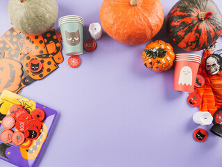 Halloween purple frame background flatlay with pumpkins and party decor