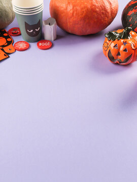 Halloween purple frame background flatlay with pumpkins and party decor