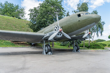 Vintage olive green military airplane with white markings, prominently featured propellers, cockpit...