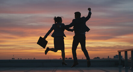 Dynamic business team celebrating success, jumping with joy against a stunning sunset, symbolizing achievement and teamwork after reaching goals together