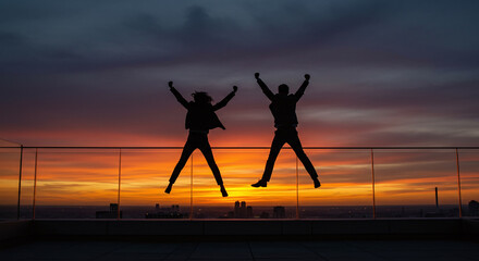 Celebrating Team Success at Sunset Viewpoint, Dynamic Duo Jumping with Excitement, Business Achievement and Urban Joy, Professional Milestone Reached Together