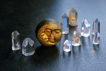 clear quartz minerals and symbolic moon amulet close up on dark abstract background. Witchcraft,...