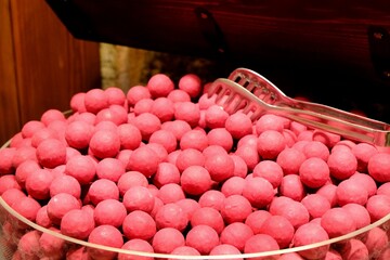 Round pink candies sold in a candy store, close-up. Green round pink candies for children....