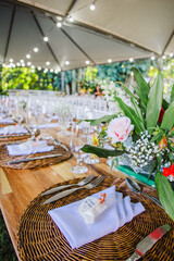 Outdoor wedding reception table with a party favor on a rustic place setting.