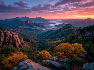 Sunset over mountainous terrain during fall Orange, pink, blue, purple skies with scattered clouds Rugged mountains, covered in yellow, red, and green foliage Contrasting rocky peaks - AI-Generated