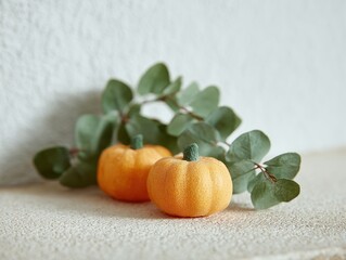 Bright Orange Pumpkins Surrounded by Green Eucalyptus Leaves