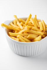 Crispy golden French fries in a white bowl on a clean white background. Classic fast food snack, appetizing and freshly cooked, ideal for menu, advertising, or lifestyle content.