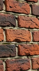 Close-up of a textured brick wall with varying shades of red and brown.