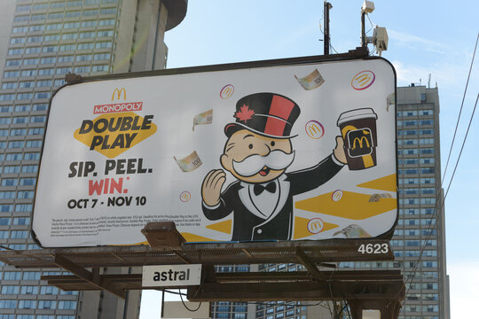 traditional roadside billboard featuring McDonald's Canada promotional event (Monopoly Double Play) off Queens Quay E, Toronto