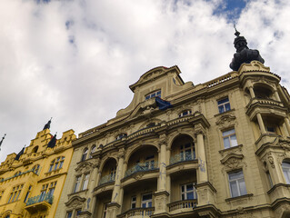Fototapeta premium Wide angle shot of a row of magnificent classical buildings with diverse architectural styles and ornate details standing under a blue sky with white fluffy clouds.