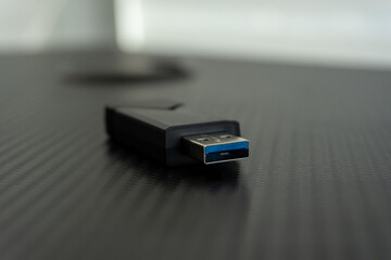 USB 3.0 flash drive lying on dark textured surface, close up data storage device on desk, technology information transfer