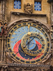 Obraz premium Macro shot of a stunning medieval astronomical clock with intricate golden dials and colorful segments representing time and celestial movements.