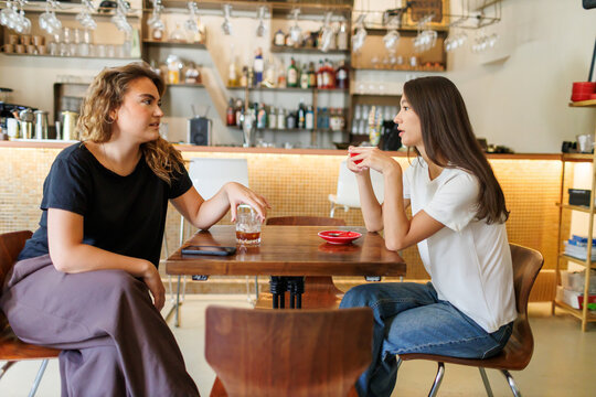 Two Girlfriends having a deep conversation at a cozy cafe in the afternoon - Powered by Adobe