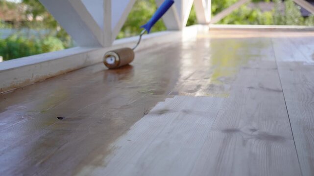 Applying fresh varnish on wooden deck: smooth transformation in progress