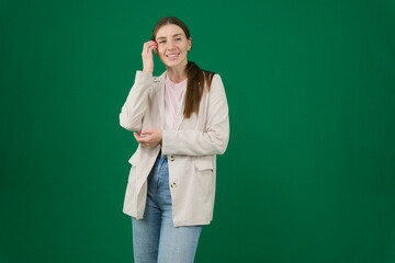 Professional photo collection of young European woman in light blazer with hair tied in ponytail and blue jeans on green chroma key background expressing different emotions and gestures perfect for ad