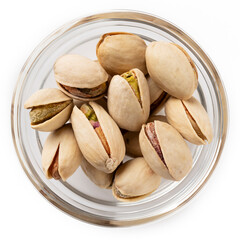 Top view of roasted pistachio nuts in a glass bowl isolated on white background for food photography.