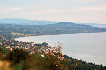 A breathtaking aerial view of a coastline bathed in pre-sunset light, where the golden hour transforms the landscape into a masterpiece of warm tones.