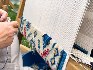 Carpet weaving using traditional techniques on a loom. , close-up of weaving and handmade carpet production.