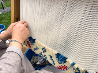 Carpet weaving using traditional techniques on a loom. , close-up of weaving and handmade carpet production.
