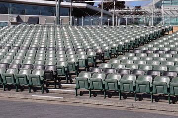 Empty seats and large stairs in a stadium. Rows of seats. Summer and autumn event and outdoor amphitheater.
