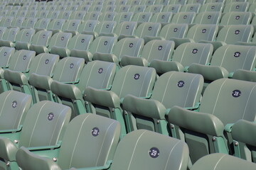 Naklejka premium Rows of seats in stadium and outdoor event in summer. Outdoor architecture and exterior amphitheater with green seats. Seats design and public stadium. Outdoor show in summer.