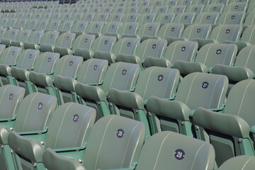 Fototapeta premium Rows of seats in stadium and outdoor event in summer. Outdoor architecture and exterior amphitheater with green seats. Seats design and public stadium. Outdoor show in summer.