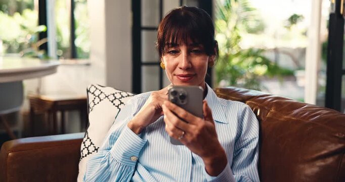 Reading, smile or mature woman on sofa with phone, entertainment update or funny post on online app. Digital, scroll and female person in house with tech, meme reaction or good news on email.