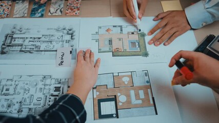 Two hands engage with architectural blueprints and design plans on a table, highlighting collaboration and the creative process in modern architecture development. SACTR