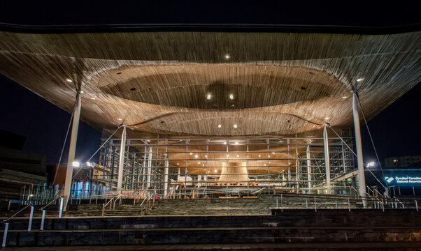 Cardiff, United Kingdom, April 20, 2019. The front view of The Senedd, the Welsh National Assembly building illuminated with lights during the evening.