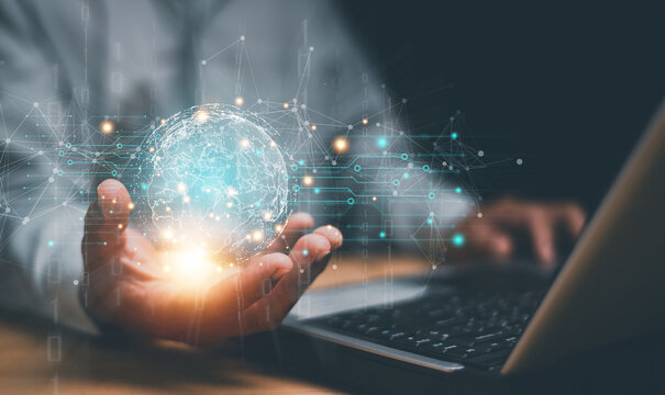 Global network technology concept. Businessman using laptop and holding glowing digital globe. Worldwide connectivity, data exchange, communication and futuristic digital transformation.