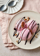 pink raspberry ice cream decorated with chocolate sauce on plate