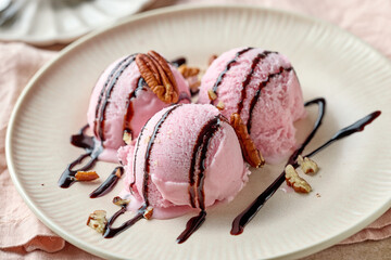 pink raspberry ice cream decorated with chocolate sauce on plate