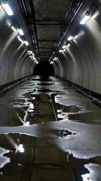 Tunnel souterrain avec flaques d&rsquo;eau et lumi&egrave;re froide