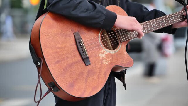 Man playing acoustic guitar on street busking