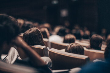 Rear view of unrecognizable people in audience at the conference hall. Business and entrepreneurship symposium