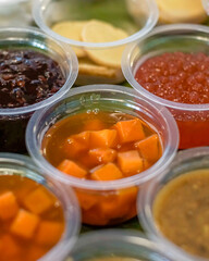 Close-up of traditional Indonesian sweet porridges including bubur ketela, bubur candil, bubur kacang hijau, and bubur ketan hitam served in clear plastic cups