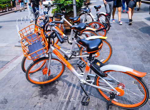Changsha, China, July, 2017.  The orange-color bikes lined up on street, the bike-sharing operated by Mobike.
