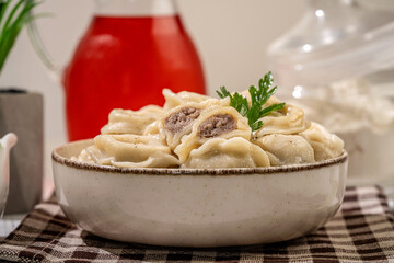 Boiled dumplings with meat filling and parsley in bowl
