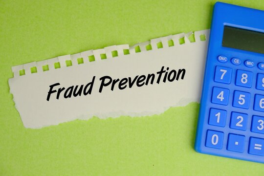 FRAUD PREVENTION text on torn paper over green background. Business services metaphor and law enforcement concept for countermeasures to internet fraud, identity theft and computer crime.