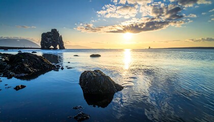 Coastal landscape at sunset, serene water reflects golden light
