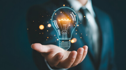 Businessman holding glowing lightbulb symbolizing innovation and new ideas for success