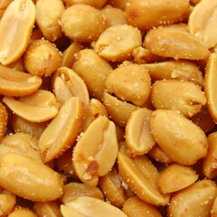 Roasted peanut kernels scattered in warm gold hue