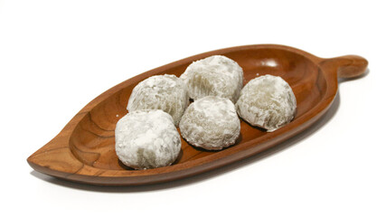 Mochi, a sweet dessert or rice cake filled with chocolate or mung beans, and coated with sesame seeds Mochi cake on a plate with a white background.