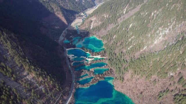 Drone view of Jiuzhaigou National Park in spring in Sichuan Province China. It features cascading waterfalls, turquoise blue lakes, and stunning mountain valleys. 4K real time footage travel concept.