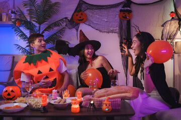 Friends celebrating halloween party at home with costumes