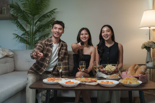 Friends enjoying night watching television and eating pizza