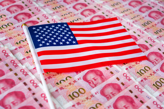 Trade tension, trade war or commercial conflict between US and China, economic concept : Chinese yuan or renminbi bill with the American flag. Depicting the trade war between the two major economies. - Powered by Adobe